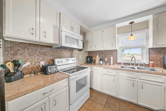 kitchen featuring light countertops, white appliances, backsplash, and a sink