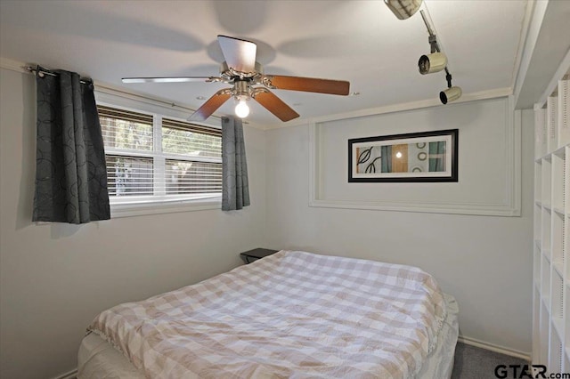 carpeted bedroom featuring ceiling fan and crown molding