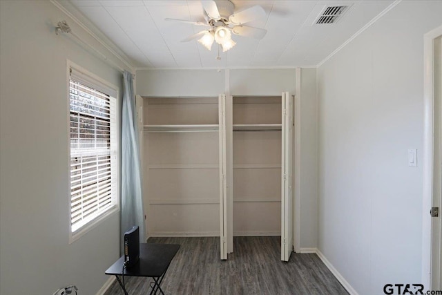 unfurnished bedroom featuring ornamental molding, dark wood-type flooring, and ceiling fan