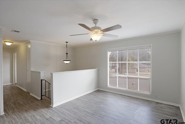 spare room with hardwood / wood-style flooring, ceiling fan, and crown molding