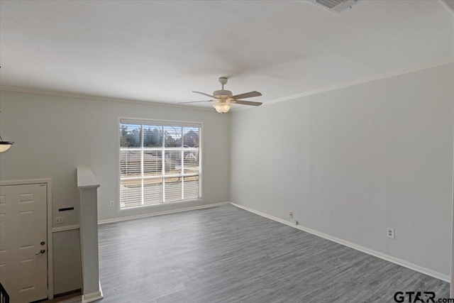 unfurnished living room featuring a textured ceiling, wood-type flooring, ceiling fan, and crown molding