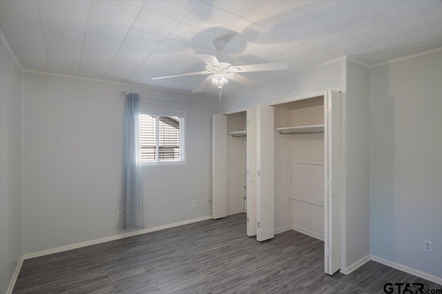 unfurnished bedroom featuring dark wood-type flooring, ceiling fan, a closet, and ornamental molding