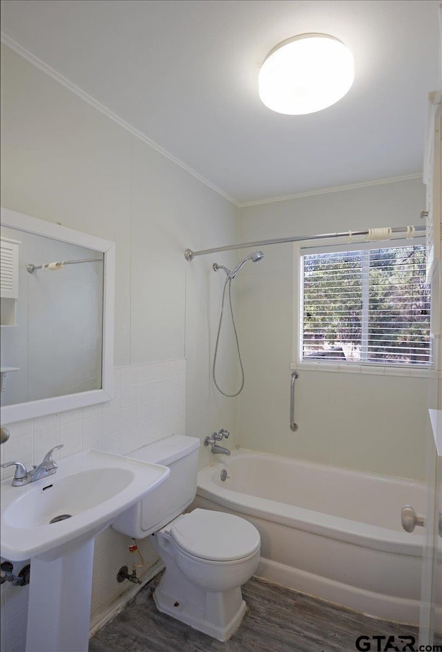 full bathroom featuring wood-type flooring, bathtub / shower combination, tile walls, and toilet