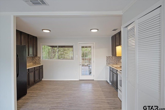 kitchen featuring black fridge, decorative backsplash, white range with electric cooktop, and light wood-type flooring