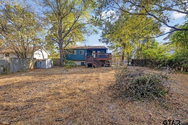 back of property with a deck and a storage unit