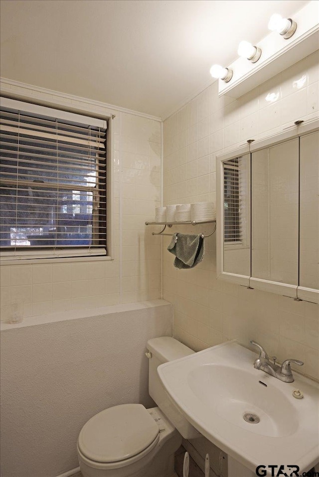 bathroom featuring sink, decorative backsplash, tile walls, and toilet