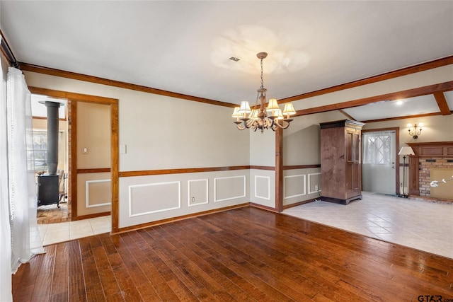 empty room featuring light hardwood / wood-style flooring, crown molding, and a chandelier