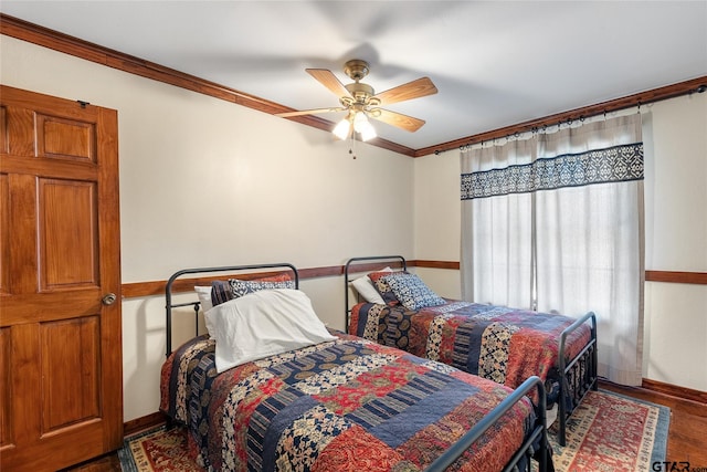 bedroom featuring ceiling fan, crown molding, and hardwood / wood-style flooring