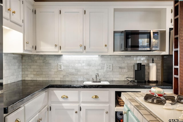 kitchen featuring sink, backsplash, and white cabinets