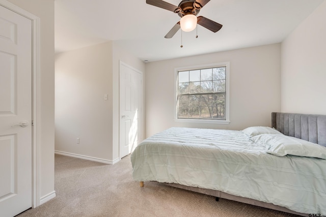 bedroom with light colored carpet, baseboards, and ceiling fan