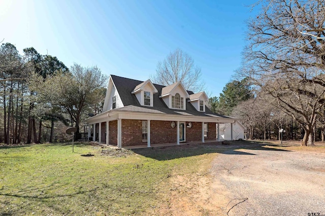 view of side of home with a yard, brick siding, and dirt driveway