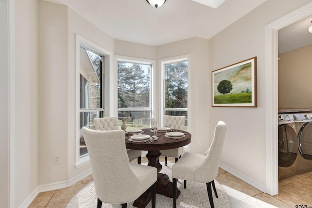 dining area with light tile patterned flooring, separate washer and dryer, and baseboards