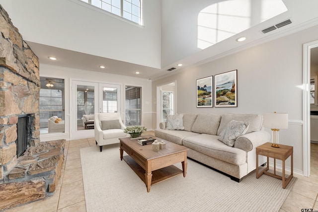 living area with light tile patterned floors, visible vents, ornamental molding, and french doors