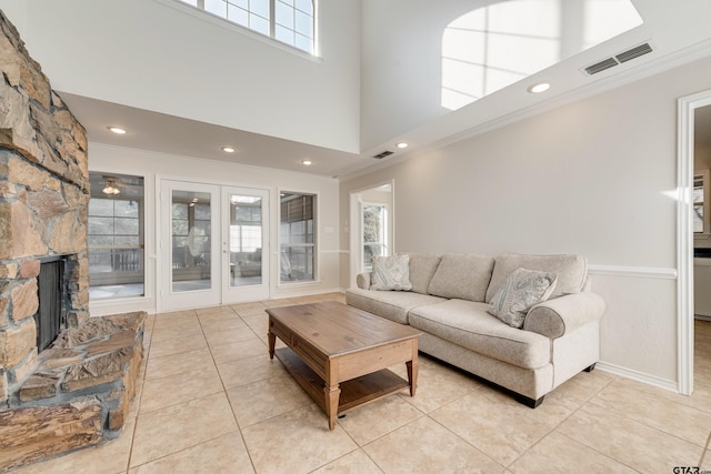 living room with light tile patterned floors, visible vents, and crown molding