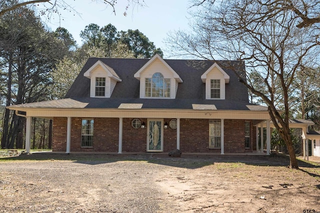 view of front of house featuring brick siding and a porch