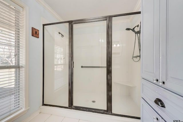 full bathroom with tile patterned floors, ornamental molding, and a shower stall