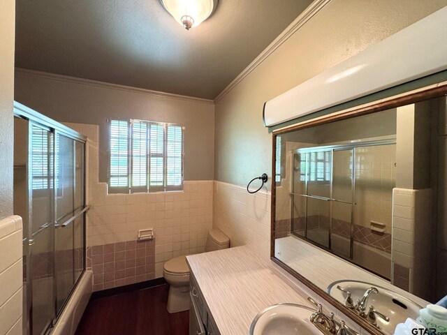 1207 E Redbud Ave, Crockett, TX 75835 - bathroom featuring vanity, tile walls, toilet, ornamental molding, and wood finished floors