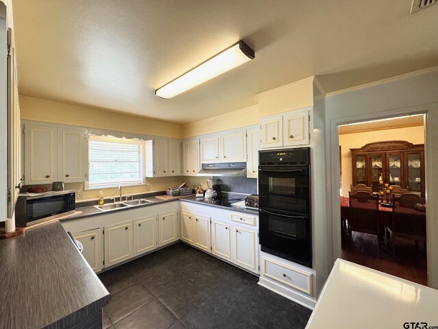 1207 E Redbud Ave, Crockett, TX 75835 - kitchen with white cabinetry, under cabinet range hood, a sink, visible vents, and black appliances