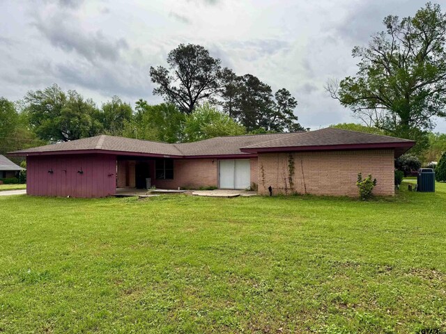 1207 E Redbud Ave, Crockett, TX 75835 - rear view of property with brick siding, central AC, and a yard