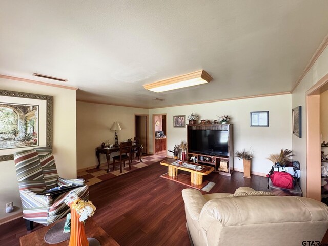 1207 E Redbud Ave, Crockett, TX 75835 - living area with ornamental molding, dark wood-style floors, baseboards, and visible vents