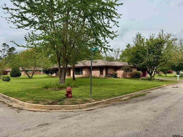 1207 E Redbud Ave, Crockett, TX 75835 - ranch-style house featuring a front lawn