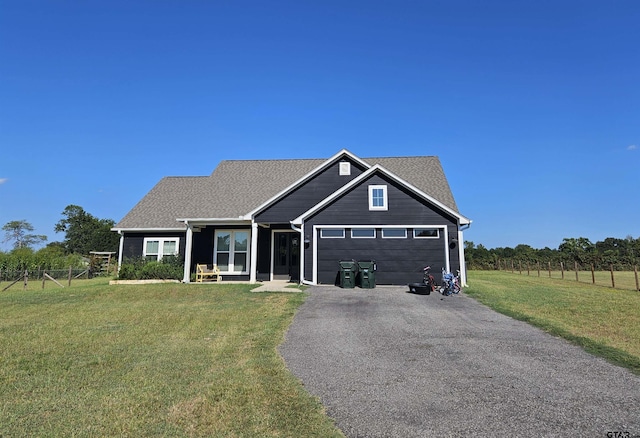 view of front of home with aphalt driveway, a garage, a front lawn, and fence