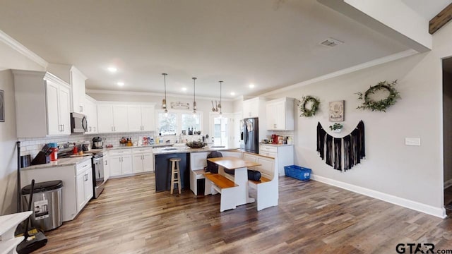 kitchen with a center island, visible vents, backsplash, and stainless steel appliances
