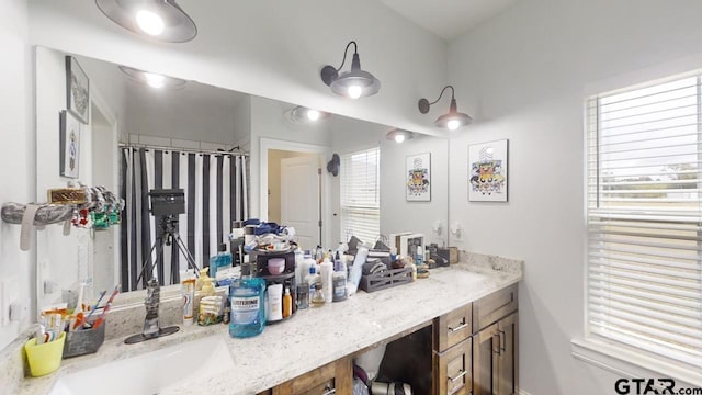 bathroom featuring a sink, a healthy amount of sunlight, and double vanity