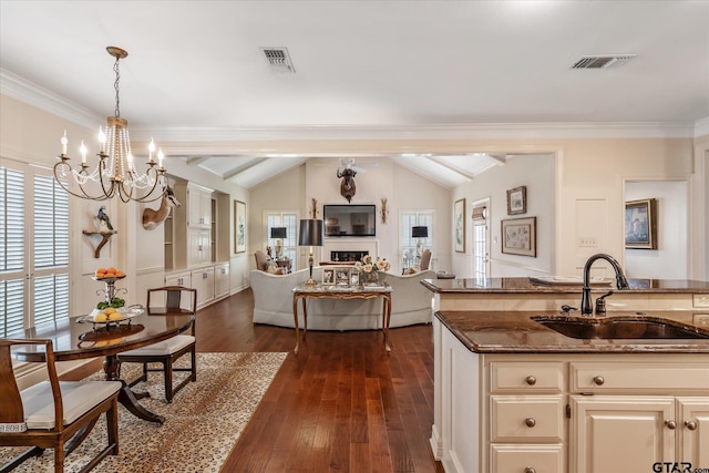 2003 Royal Oak Dr, Tyler, TX 75703 - kitchen featuring a sink, a chandelier, vaulted ceiling, dark stone countertops, and open floor plan
