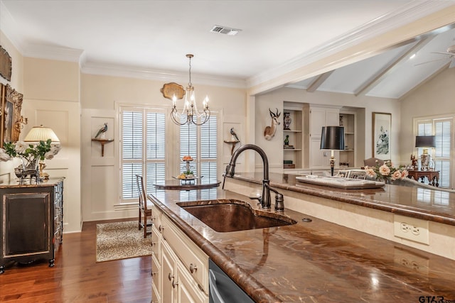 2003 Royal Oak Dr, Tyler, TX 75703 - kitchen with a sink, dark wood-style floors, dark stone counters, a chandelier, and decorative light fixtures