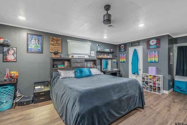 bedroom with light hardwood / wood-style floors and crown molding