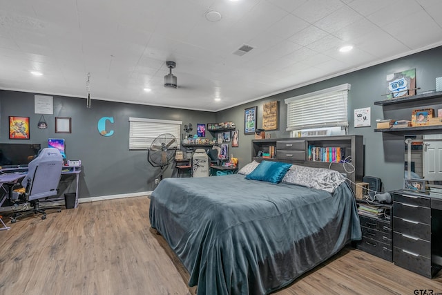 bedroom featuring hardwood / wood-style flooring and crown molding