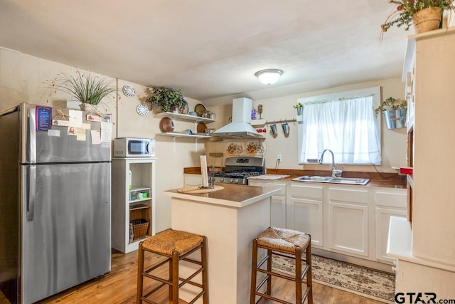 2200 N Horn Ave, Tyler, TX 75702 - kitchen with appliances with stainless steel finishes, a sink, wall chimney range hood, white cabinets, and open shelves