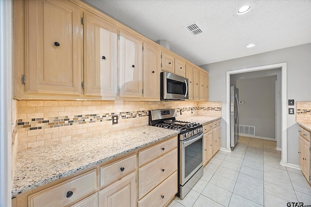 223 Guadalupe Dr, Athens, TX 75751 - kitchen featuring appliances with stainless steel finishes, light brown cabinetry, light stone countertops, a textured ceiling, and recessed lighting
