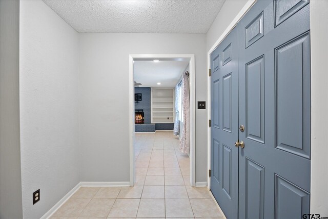 223 Guadalupe Dr, Athens, TX 75751 - hall featuring baseboards, light tile patterned flooring, a textured ceiling, and built in shelves