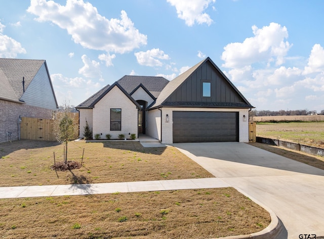 modern farmhouse style home featuring board and batten siding, a front yard, fence, a garage, and driveway