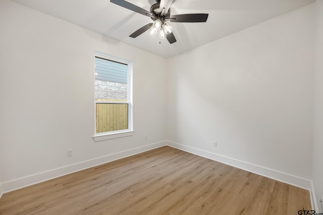 spare room with light wood-type flooring, ceiling fan, and baseboards