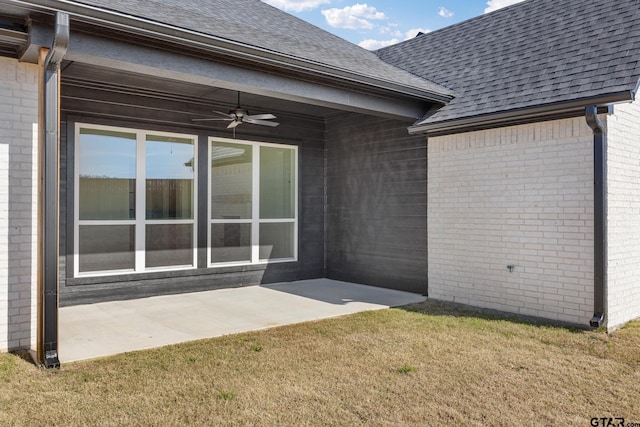 back of house with brick siding, a patio area, and roof with shingles