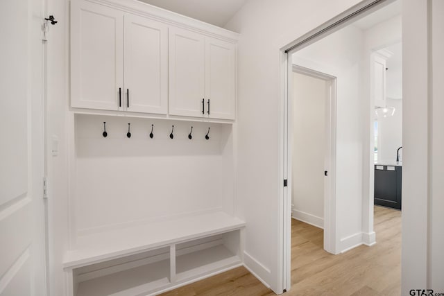 mudroom with light wood-style flooring and baseboards