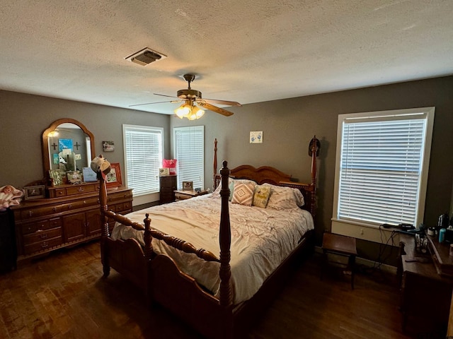 bedroom featuring dark hardwood / wood-style flooring, a textured ceiling, and ceiling fan