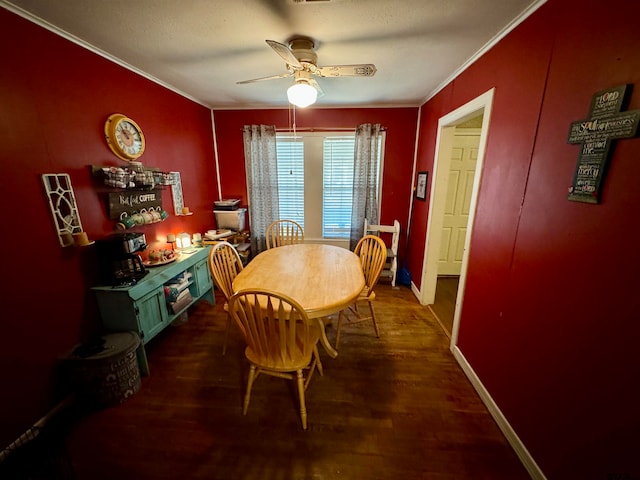 dining room featuring dark wood-type flooring, ornamental molding, and ceiling fan