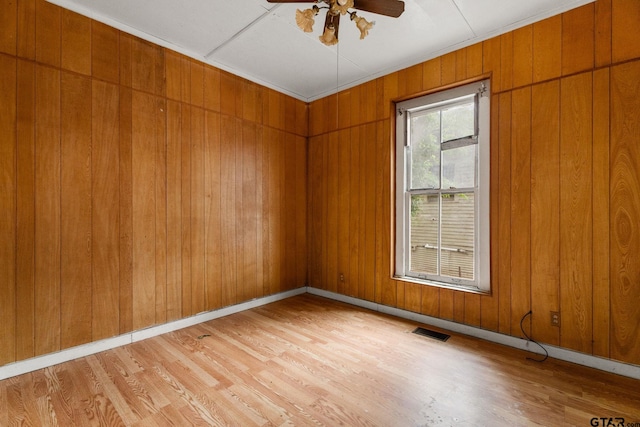 210 S Adams Ave, Tyler, TX 75702 - empty room with light wood-type flooring, wood walls, visible vents, baseboards, and ceiling fan