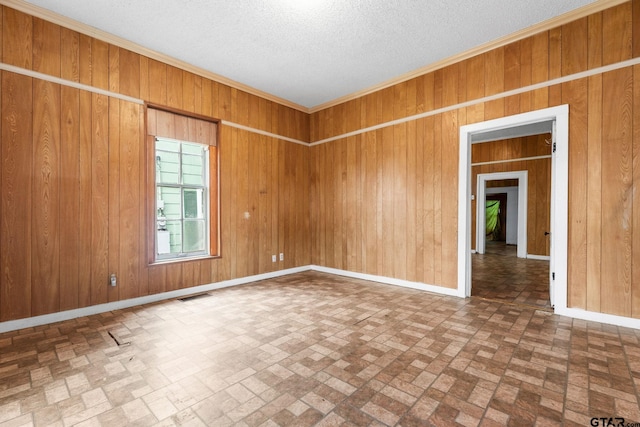 210 S Adams Ave, Tyler, TX 75702 - spare room with brick patterned floor, wood walls, and visible vents