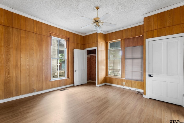 210 S Adams Ave, Tyler, TX 75702 - unfurnished bedroom with wood walls, crown molding, visible vents, and wood finished floors