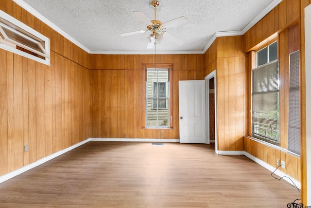 210 S Adams Ave, Tyler, TX 75702 - unfurnished room with light wood finished floors, a textured ceiling, wood walls, and baseboards