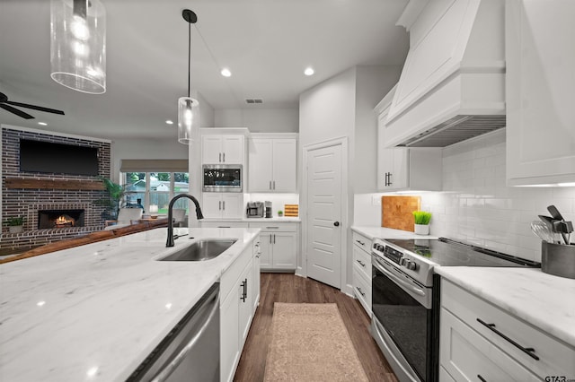401 Deer Point Cv, Chandler, TX 75758 - kitchen featuring appliances with stainless steel finishes, premium range hood, dark wood-type flooring, white cabinetry, and open floor plan