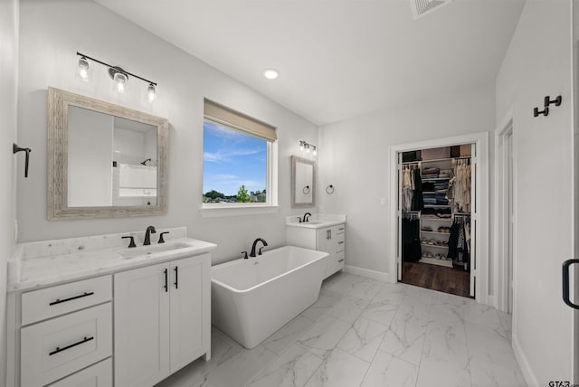 401 Deer Point Cv, Chandler, TX 75758 - full bath featuring two vanities, a freestanding tub, marble finish flooring, a walk in closet, and recessed lighting