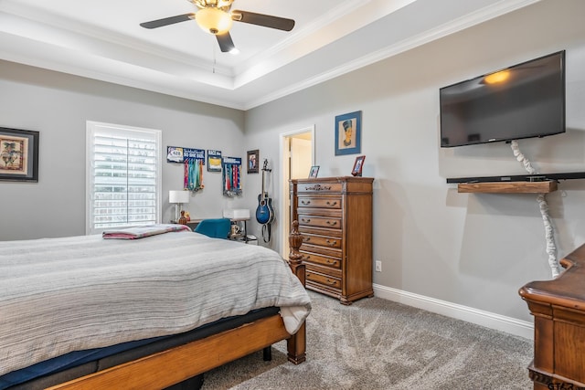 bedroom featuring ornamental molding, carpet flooring, ceiling fan, and a tray ceiling