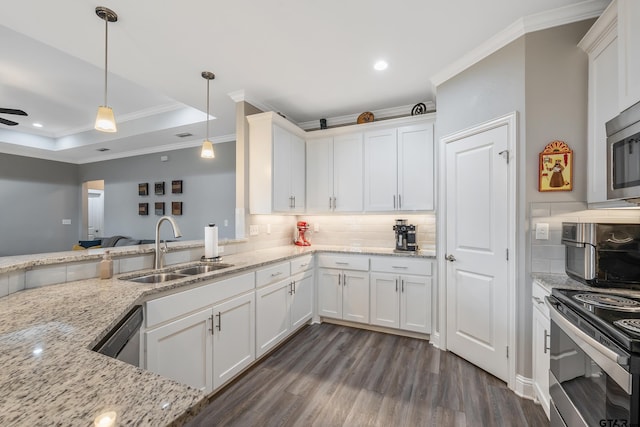 kitchen featuring sink, light stone counters, white cabinets, decorative light fixtures, and a raised ceiling