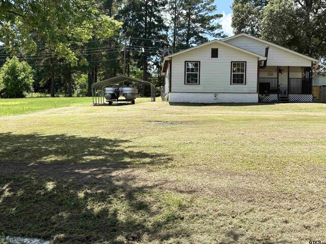 9394 Grape Ave, Frankston, TX 75763 - view of home's exterior featuring a detached carport, a yard, and a porch